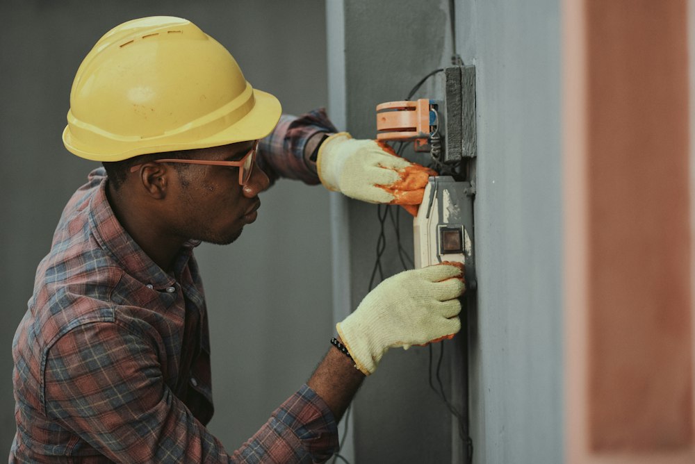 Electrician in a hard hat working on building wiring